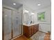 Bright bathroom with a glass enclosed shower and double sink vanity with decorative mirrors and lighting at 627 S Chapel St, Landis, NC 28088