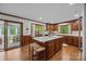 Bright kitchen featuring an island with a marble countertop, wood cabinets, and views to the sunroom at 627 S Chapel St, Landis, NC 28088