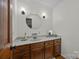 Powder room with wooden cabinets, gray countertop, and a round mirror above the sink at 627 S Chapel St, Landis, NC 28088