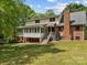 Two-story home with a brick chimney, deck, and lush green lawn at 627 S Chapel St, Landis, NC 28088
