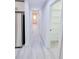 Bright hallway with light wood flooring, white walls, and a view of the pantry and the entry door at the end at 721 32Nd Ne St, Conover, NC 28613