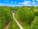 Secluded stone home with long driveway nestled in a lush green forest with beautiful blue skies at 8451 Ridgewood Rd, Sherrills Ford, NC 28673