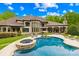 Back of house with beautiful pool and jacuzzi surrounded by chairs and umbrella to stay cool on a hot day at 8451 Ridgewood Rd, Sherrills Ford, NC 28673