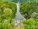 Aerial view of a tranquil waterfront featuring multiple boat docks surrounded by lush greenery at 8451 Ridgewood Rd, Sherrills Ford, NC 28673
