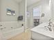 Bright bathroom features a tub, glass-door shower, and double sink vanity with neutral tones at 9640 Alma Blount Blvd, Charlotte, NC 28277