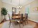 Bright dining room featuring a wooden table, six chairs, and hardwood floors with a jute rug at 9640 Alma Blount Blvd, Charlotte, NC 28277