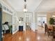 Bright living room featuring hardwood floors and an open doorway to the kitchen and dining area at 9640 Alma Blount Blvd, Charlotte, NC 28277