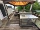 Spacious deck featuring an outdoor kitchen complete with a stainless steel grill and shaded by an umbrella at 102 Eagle Ln, New London, NC 28127