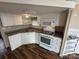 Modern kitchen with white cabinets, updated appliances, and beautiful hardwood floors at 102 Eagle Ln, New London, NC 28127