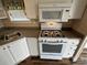 Bright kitchen featuring a gas range, microwave, and white cabinetry with updated countertops and fixtures at 102 Eagle Ln, New London, NC 28127
