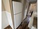 White refrigerator in the kitchen area with wood-look flooring and access to another room at 102 Eagle Ln, New London, NC 28127