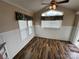 Cozy living area featuring wood-look floors, wainscoting, and large windows with modern window coverings at 102 Eagle Ln, New London, NC 28127