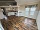 Open-concept living space with hardwood floors and kitchen featuring white cabinets at 102 Eagle Ln, New London, NC 28127