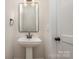 Stylish powder room featuring pedestal sink, black hardware, and neutral color palette at 106 Walters St, Huntersville, NC 28078
