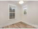 Clean, unfurnished bedroom with luxury vinyl flooring and bright natural light from two windows at 106 Walters St, Huntersville, NC 28078