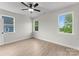 Light-filled bedroom with wood-look flooring, three windows, and a ceiling fan at 106 Walters St, Huntersville, NC 28078