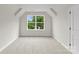 Bright bedroom featuring neutral paint, carpet, and a large window looking out onto a lush landscape at 106 Walters St, Huntersville, NC 28078