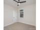 A cozy bedroom featuring a ceiling fan, a window, and a neutral carpet at 106 Walters St, Huntersville, NC 28078