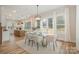 Bright dining area featuring a glass table, modern light fixture, and windows with backyard view at 106 Walters St, Huntersville, NC 28078