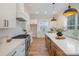Bright, modern kitchen features stainless appliances, custom cabinets, and center island with stone countertops at 106 Walters St, Huntersville, NC 28078
