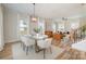 Open-concept living space with hardwood floors, a glass dining table, and stylish seating, ideal for entertaining at 106 Walters St, Huntersville, NC 28078