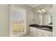 Bright bathroom with a granite countertop, large mirror, and window overlooking the yard at 107 Cedar Lake Dr, Statesville, NC 28625