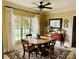 Bright dining room with hardwood table, large windows with backyard view, and neutral decor at 107 Cedar Lake Dr, Statesville, NC 28625
