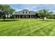 Expansive front yard with manicured lawn leads to a beautiful brick home with a covered front porch at 107 Cedar Lake Dr, Statesville, NC 28625