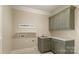 Bright laundry room with gray cabinets, tile floors, and shelving for ample storage space at 107 Cedar Lake Dr, Statesville, NC 28625