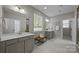 Bathroom featuring double vanity sinks, a framed mirror, and a separate shower area at 11304 Preservation Ln, Charlotte, NC 28278