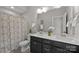 This bathroom has a double sink vanity, shower with decorative curtain, and white towels at 11304 Preservation Ln, Charlotte, NC 28278