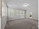 Large bedroom featuring a tray ceiling, plush carpet, recessed lights, and three large windows at 11304 Preservation Ln, Charlotte, NC 28278