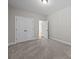 Bright bedroom with neutral carpet, white walls, closet with double doors, and entry to the next room at 11304 Preservation Ln, Charlotte, NC 28278