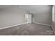 Spacious bedroom with neutral walls, carpet, and a closet as well as an entrance to the next room at 11304 Preservation Ln, Charlotte, NC 28278