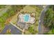 Overhead view of a community pool and clubhouse surrounded by lush landscaping and ample parking at 11304 Preservation Ln, Charlotte, NC 28278
