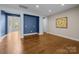 Versatile flex room with a blue accent wall and hardwood floors, perfect for an office or den at 11304 Preservation Ln, Charlotte, NC 28278