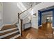 Bright foyer showcasing hardwood floors, a staircase with white railings, and decorative wainscoting at 11304 Preservation Ln, Charlotte, NC 28278