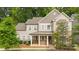Charming two-story home featuring a welcoming front porch with stone accents and a well-manicured front yard at 11304 Preservation Ln, Charlotte, NC 28278