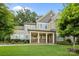 Beautiful two-story home featuring a manicured lawn, stone accents, a covered porch, and lush landscaping at 11304 Preservation Ln, Charlotte, NC 28278