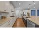 Modern kitchen with white cabinetry, granite countertops, stainless steel appliances, and a large farmhouse sink at 11304 Preservation Ln, Charlotte, NC 28278