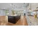 Open concept living area featuring a large island, fireplace, and hardwood floors throughout at 11304 Preservation Ln, Charlotte, NC 28278