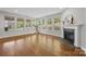 Bright sunroom with hardwood floors, a fireplace, and large windows offering a scenic view at 11304 Preservation Ln, Charlotte, NC 28278