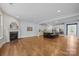 Open-concept living room featuring a fireplace, hardwood floors, and a modern kitchen with an island at 11304 Preservation Ln, Charlotte, NC 28278