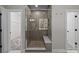 Walk-in shower features stone flooring, built-in bench, and a glass door at 11304 Preservation Ln, Charlotte, NC 28278