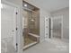 Walk-in shower with tile surround, glass door, and a built-in bench at 11304 Preservation Ln, Charlotte, NC 28278