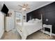 Modern bedroom with a four-poster bed, accent wall, ceiling fan, and white nightstand at 120 N Cardinal N Dr, New London, NC 28127