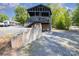 Multi-level home with exterior stairs, a gravel driveway, and natural landscaping at 120 N Cardinal N Dr, New London, NC 28127