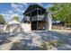 Unique exterior elevation featuring a large deck with stairs, a covered patio, and a gravel parking area at 120 N Cardinal N Dr, New London, NC 28127