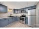 Kitchen with blue cabinets, stainless steel appliances, granite counters, and wood-look floors at 120 N Cardinal N Dr, New London, NC 28127