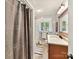 Bathroom featuring a vanity with wood cabinets, shower with curtain, and patterned floor mat at 1278 Island Creek Dr, Troy, NC 27371